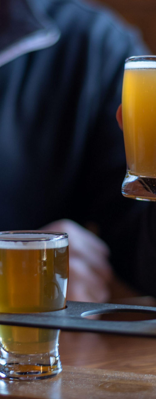 Man sampling craft beer flight indoors