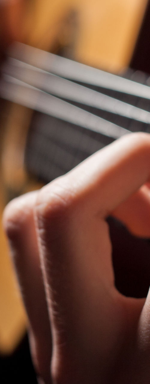Close-up of hands playing acoustic guitar