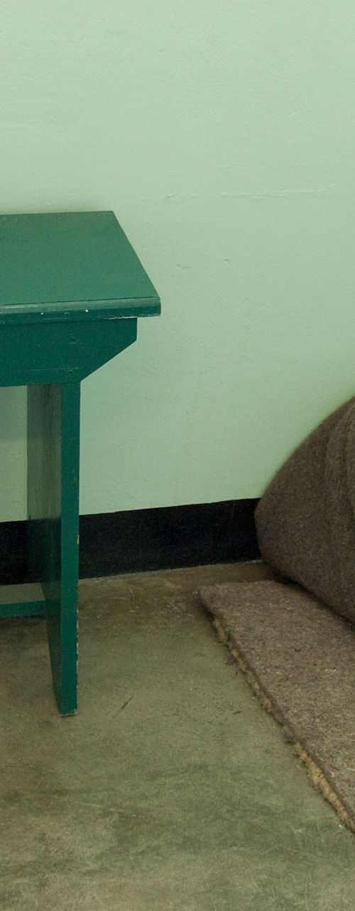 Minimal prison cell with basic furnishings
