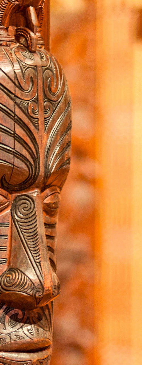 Traditional Maori wood carving in warm tones