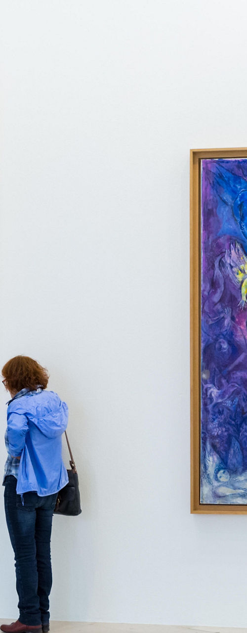 Woman admiring colorful abstract paintings