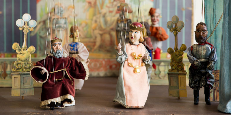 Vintage marionette puppets on miniature theater stage