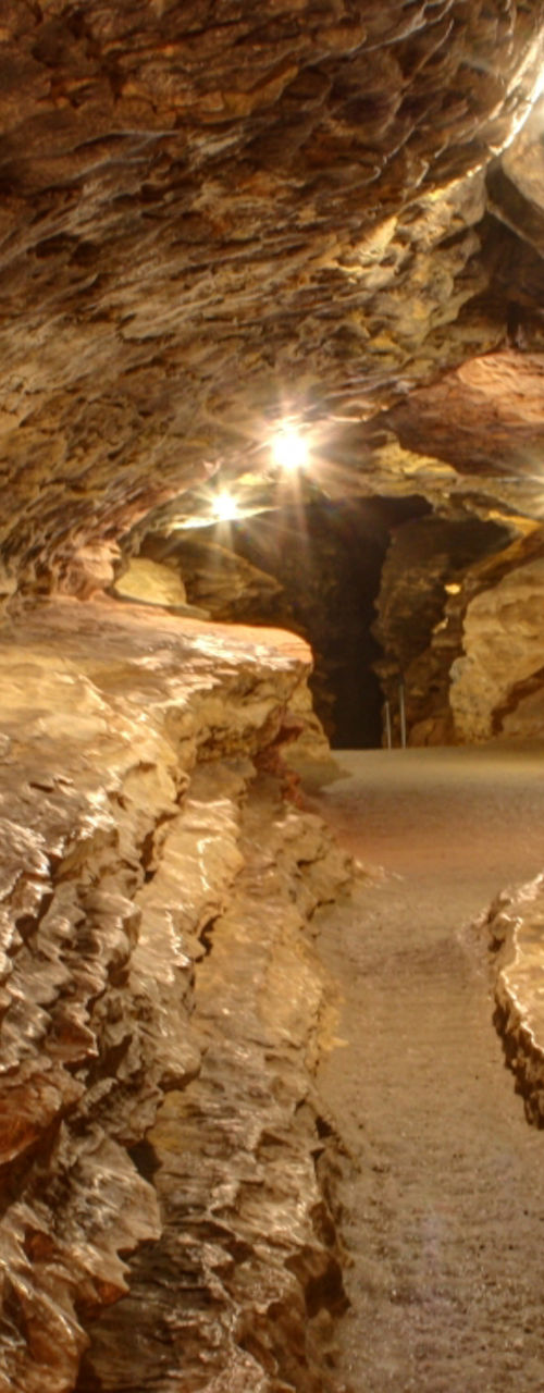 Illuminated underground rock cave pathway