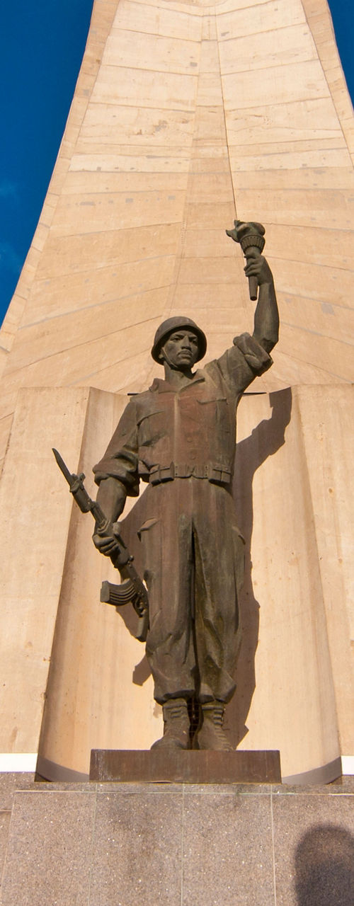 Monument with statue under blue sky