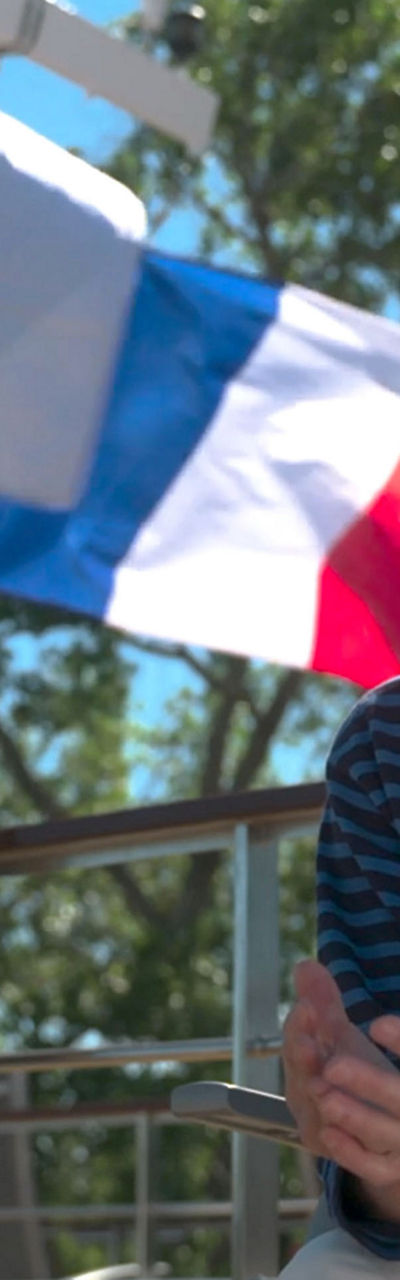 Woman seated on cruise deck with flags