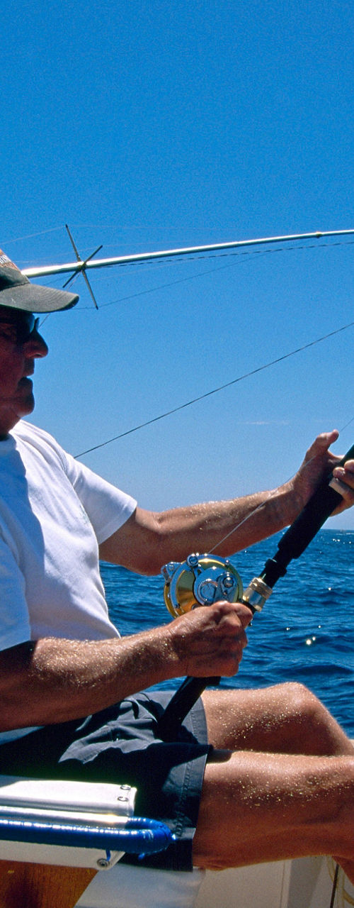Man fishing on boat in open ocean