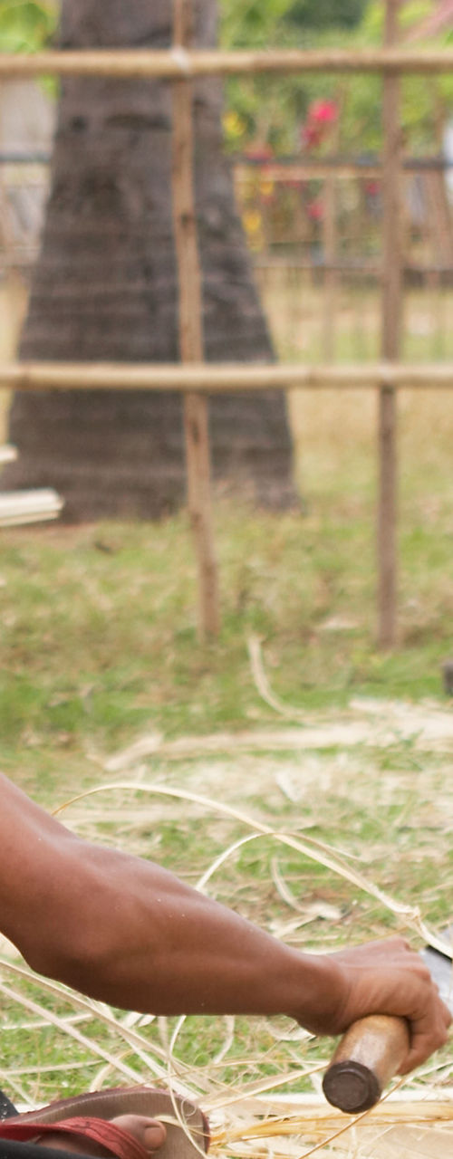 Men crafting bamboo outdoors in rural setting
