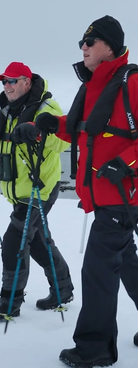 Group Trekking Across Snowy Arctic Landscape