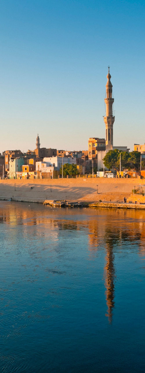 Scenic riverside town with mosque at sunrise