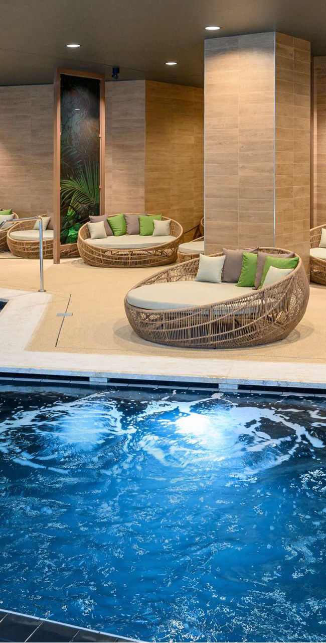Luxury indoor pool with lounge seating