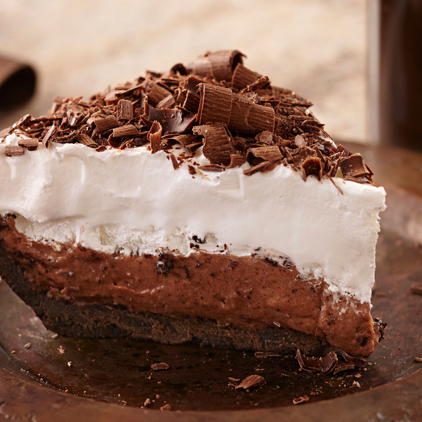 Chocolate cream pie slice on bronze plate