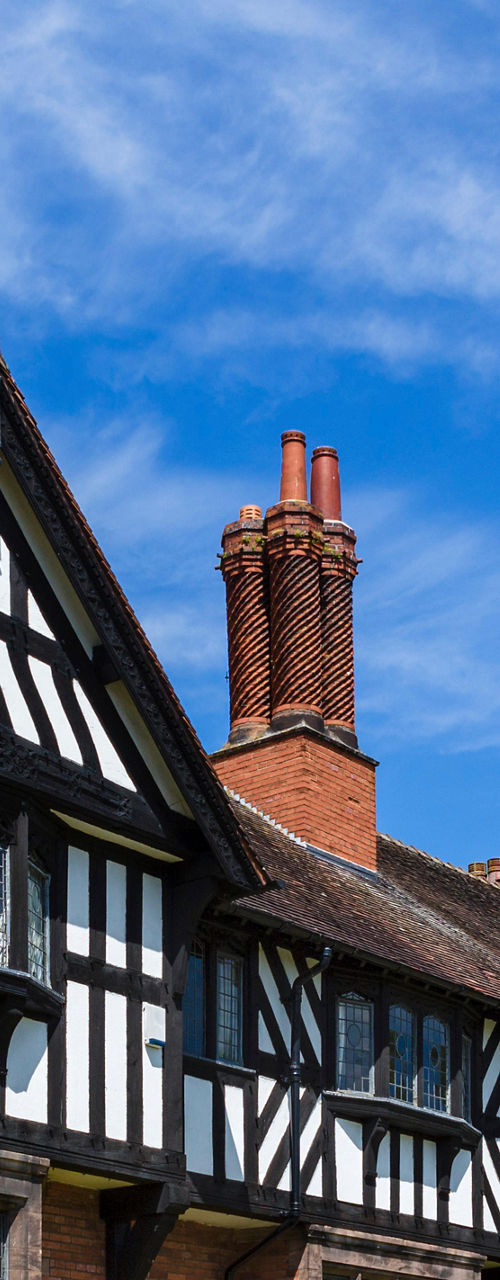 Historic Tudor-style building with lush garden
