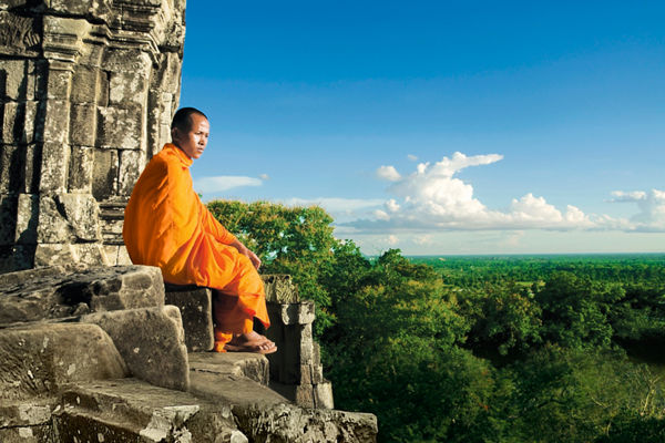 Monk sitting on ancient temple ruins