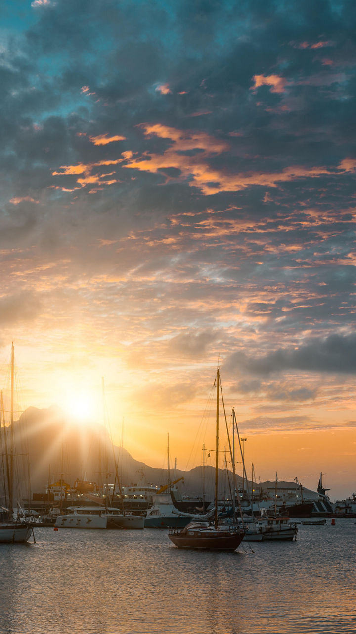 Sunset over marina with sailboats