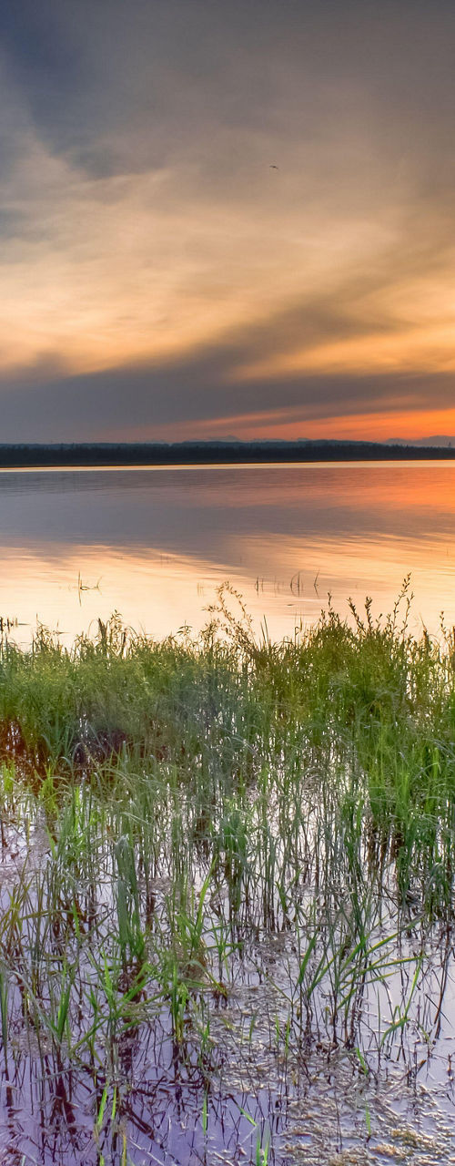 Serene lake at sunset with vibrant sky