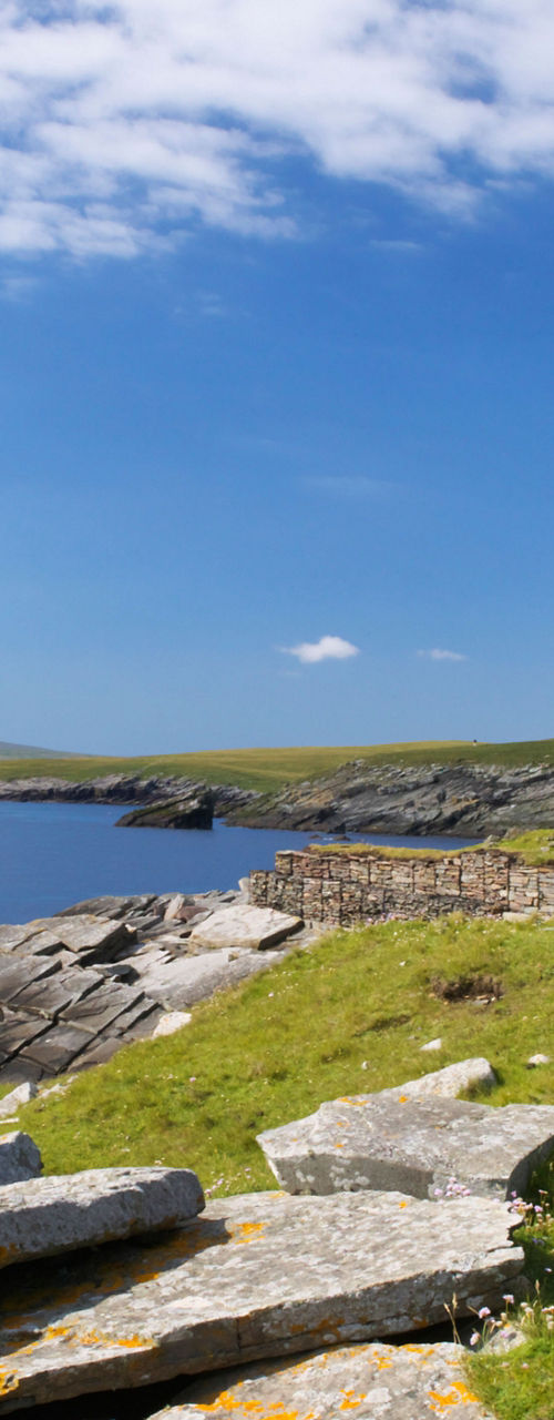 Ancient stone tower by coastal landscape