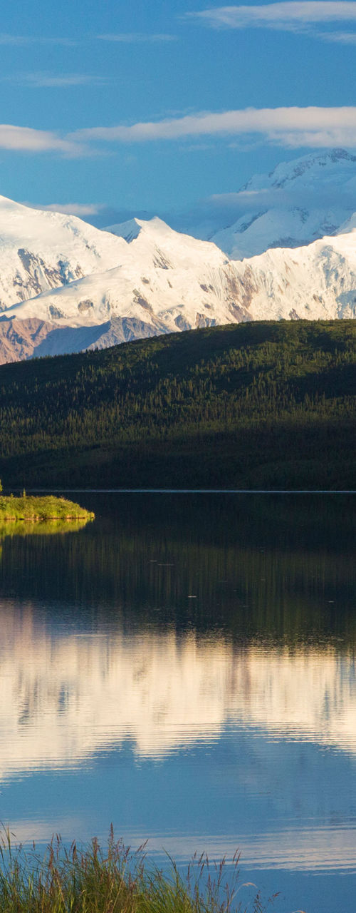 Snow-capped mountains reflected in calm lake