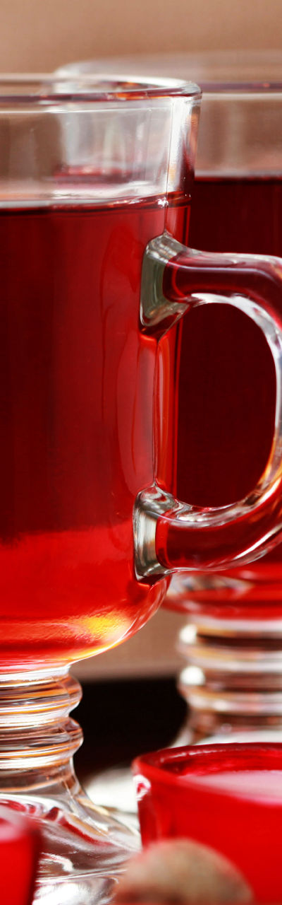 Warm spiced drink with candles and oranges