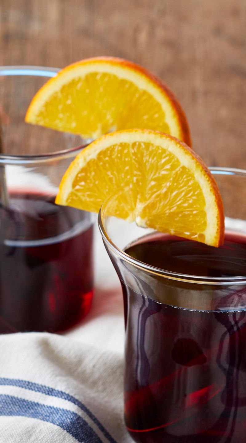 Two glass mugs of mulled wine with orange slices