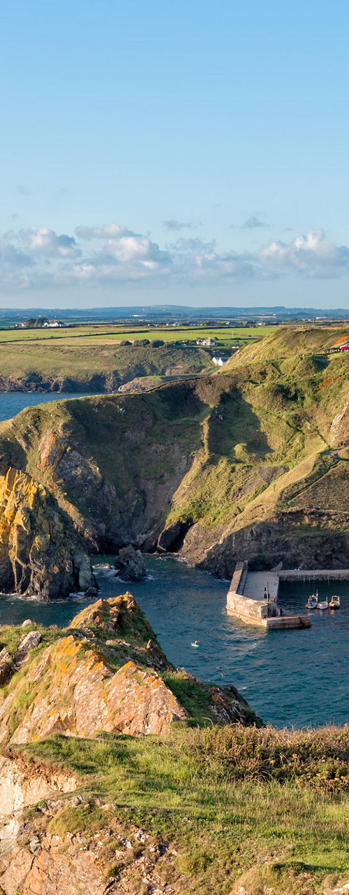 Coastal cliffs and harbor in sunny landscape