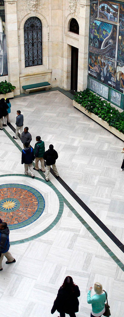 Museum visitors in mural-filled atrium