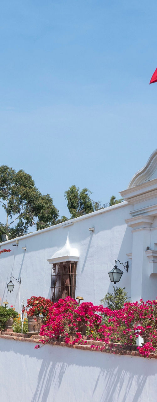 Colonial building with Peruvian flag and flowers