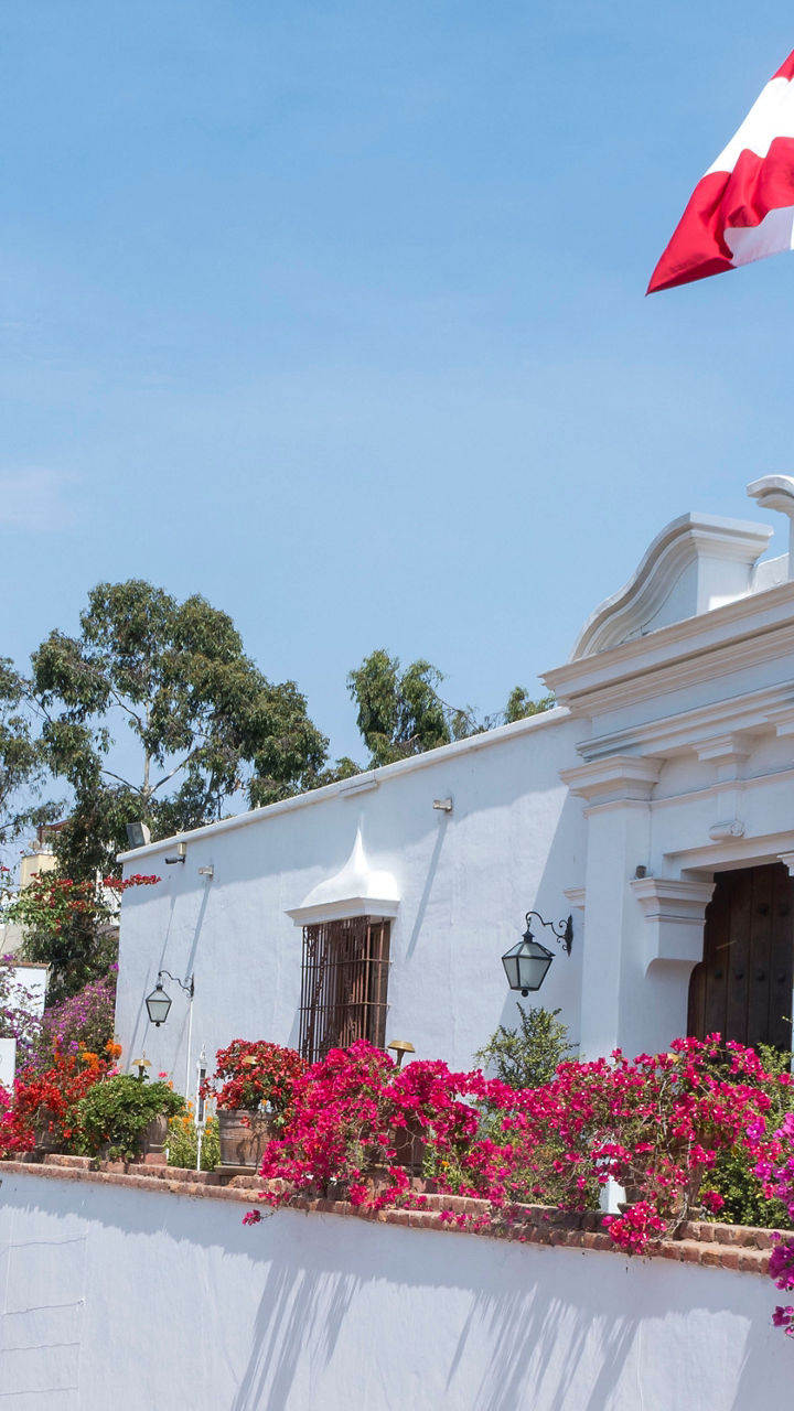 Colonial building with Peruvian flag and flowers