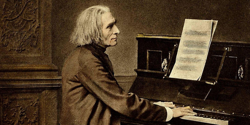 Elderly pianist seated at upright piano