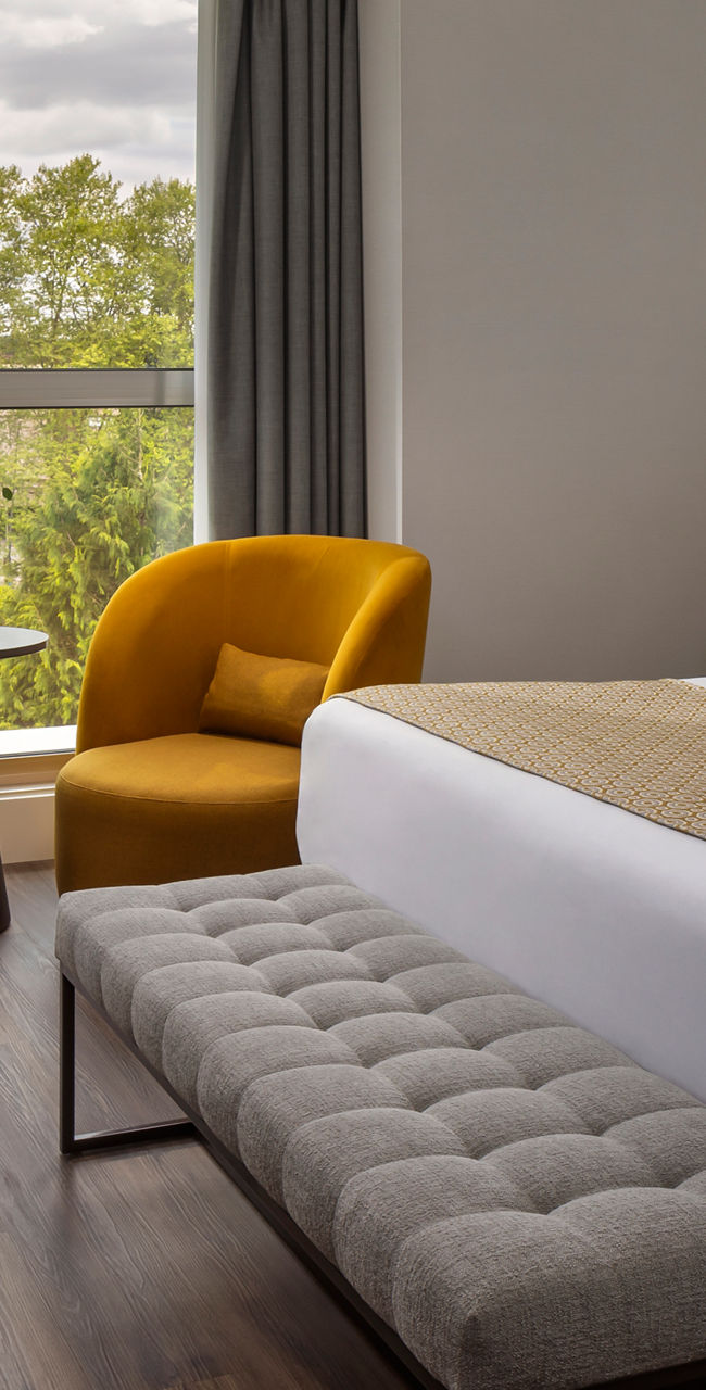 Modern hotel room with large window and seating area