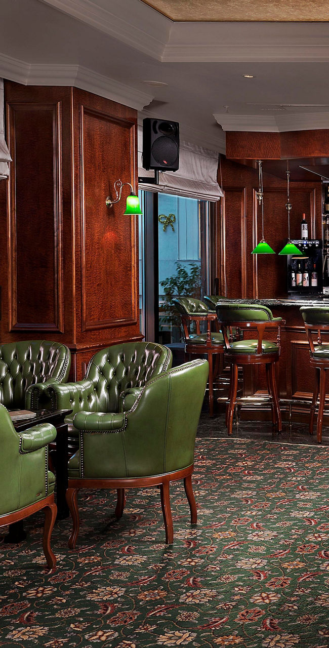 Elegant hotel bar with green leather chairs