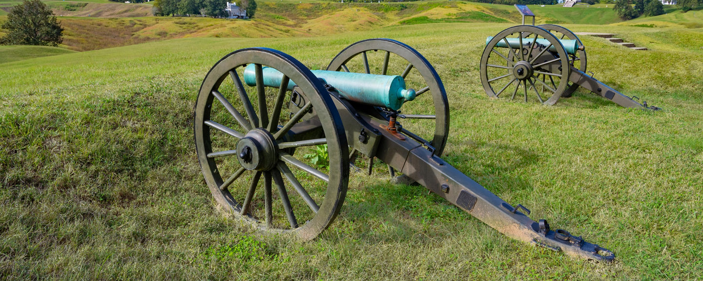 Historic cannons on grassy battlefield