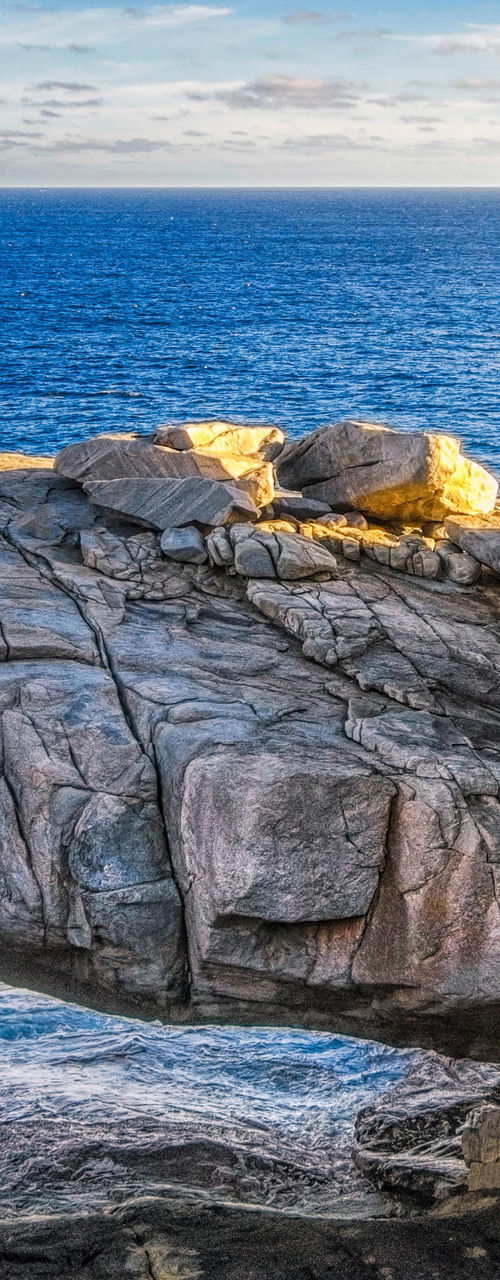 Natural rock bridge overlooking ocean sunset