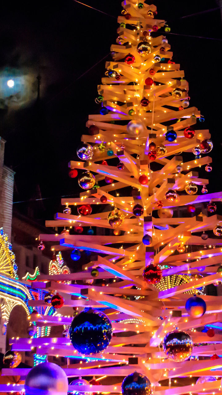 Illuminated Christmas tree in festive city square