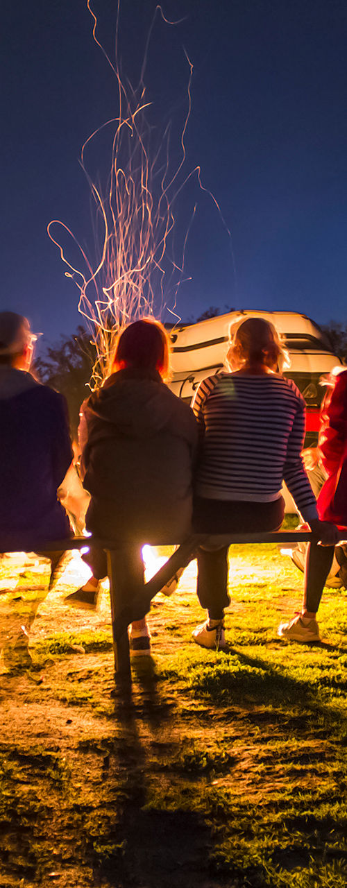 Group of friends gathered around campfire