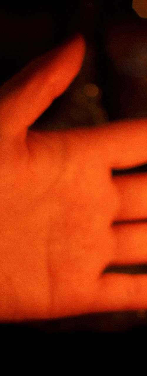 Hands warming near vintage oil lamp flame