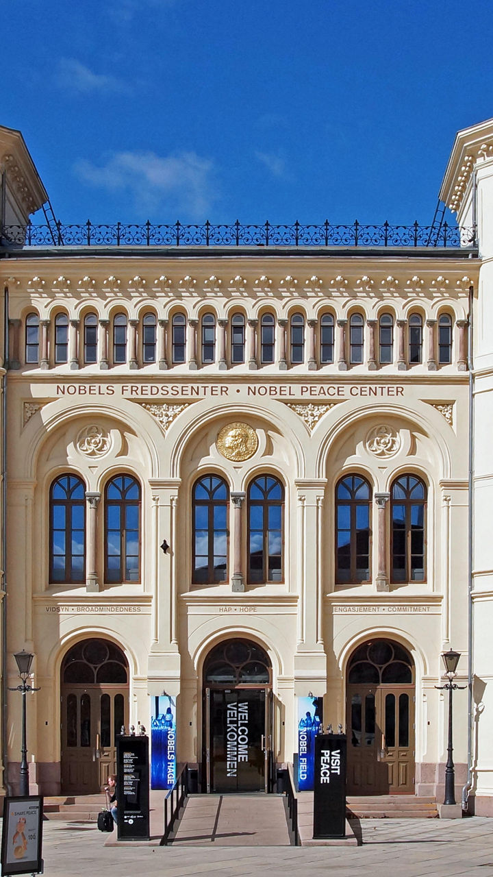 Historic building with banners in sunny plaza