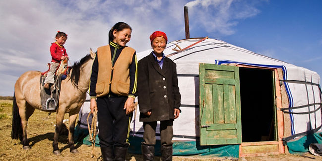 Nomadic family outside traditional yurt