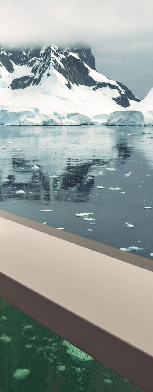 Woman observing icy landscape with binoculars