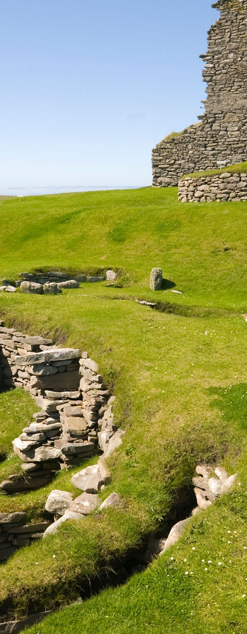 Ancient stone ruins on grassy coastline