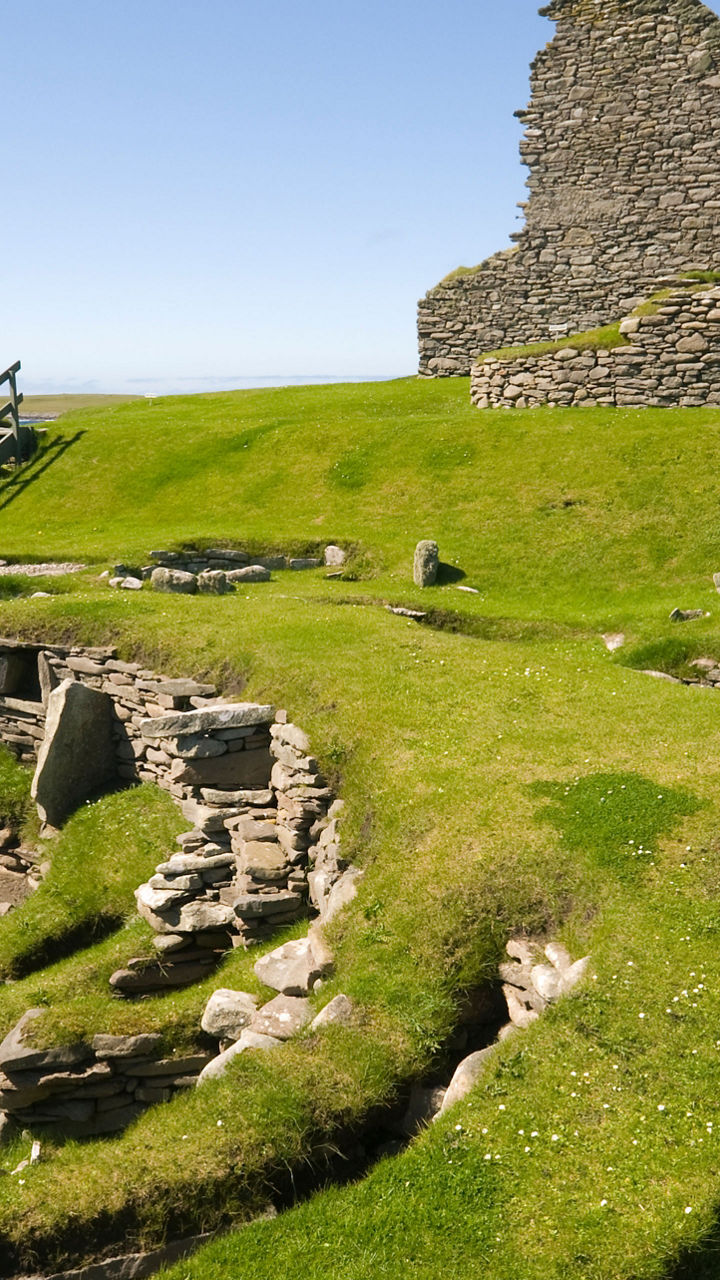 Ancient stone ruins on grassy coastline
