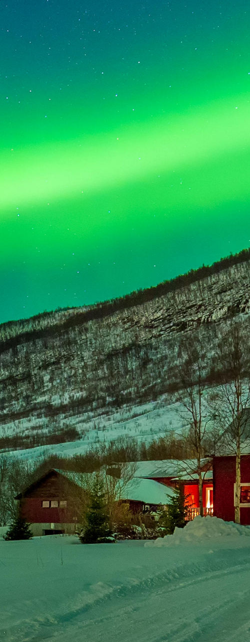 Northern Lights Over Snowy Red Cabin