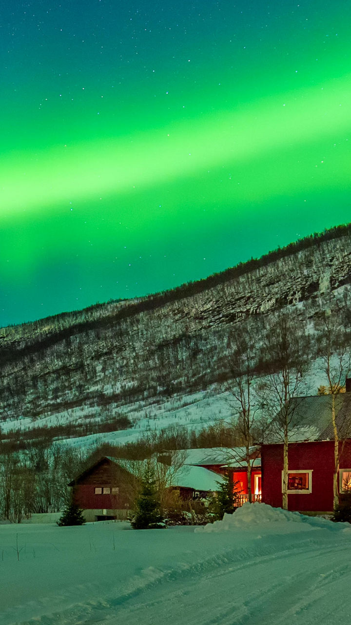 Northern Lights Over Snowy Red Cabin