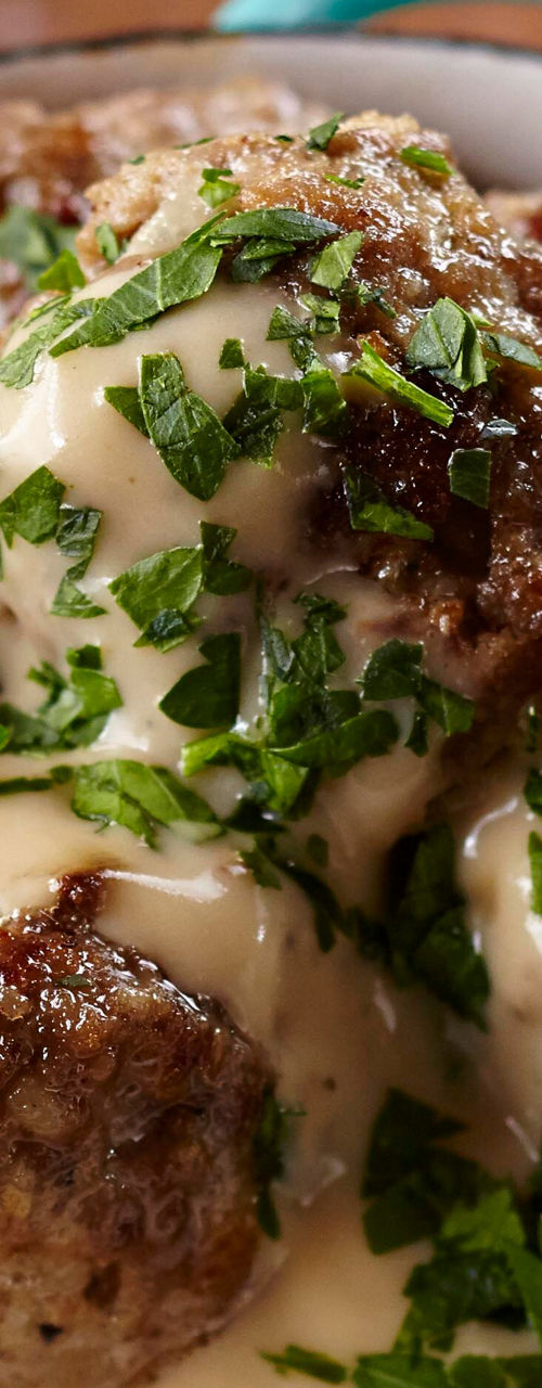 Meatballs in creamy sauce in blue bowl