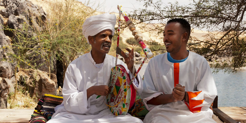 Traditional attire with cultural instrument outdoors