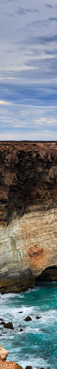 Dramatic coastal cliff under cloudy sky
