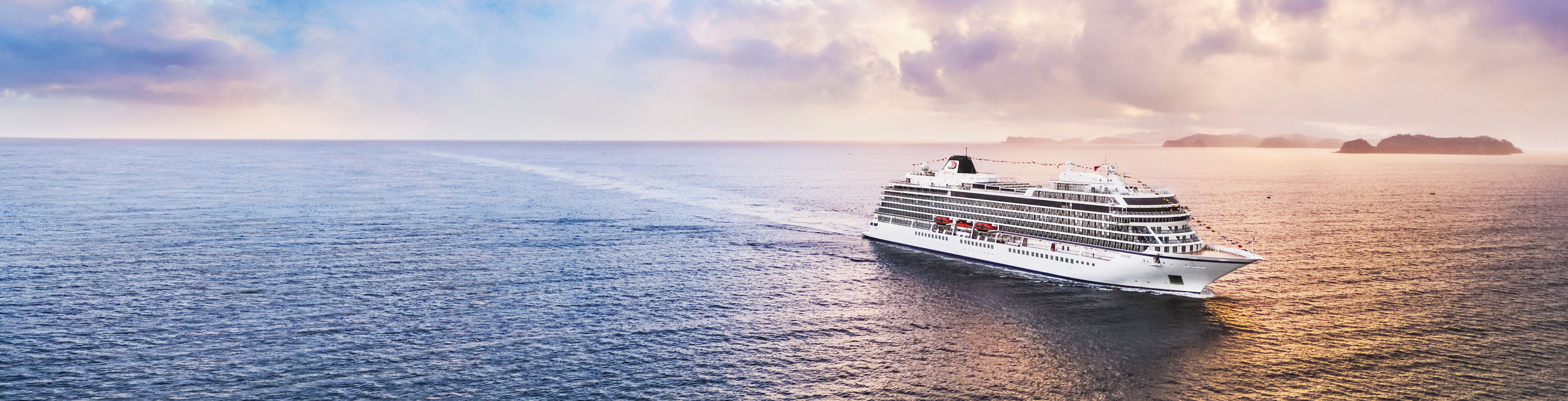 Luxury cruise ship sailing at sunset