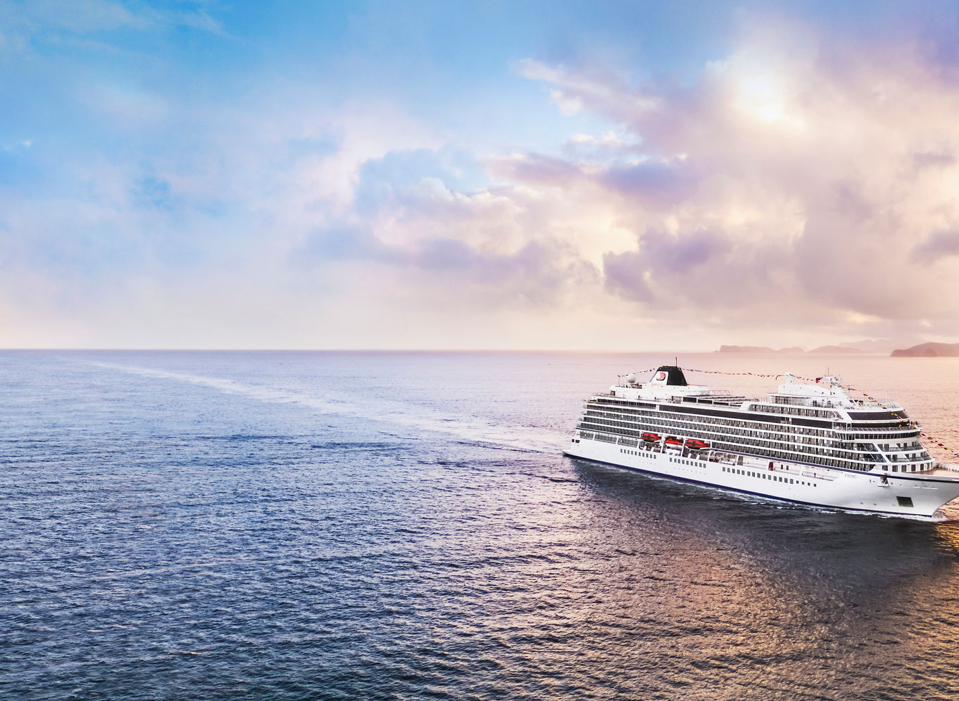 Luxury cruise ship sailing at sunset