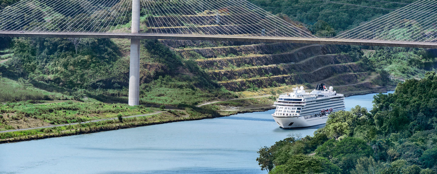 Cruise ship under cable-stayed bridge in lush valley