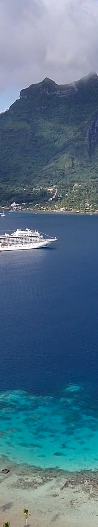 Cruise ship near tropical island and mountain