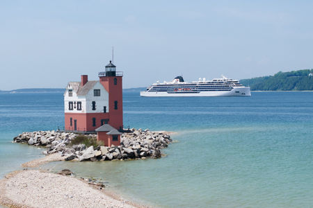 Red lighthouse with cruise ship in background